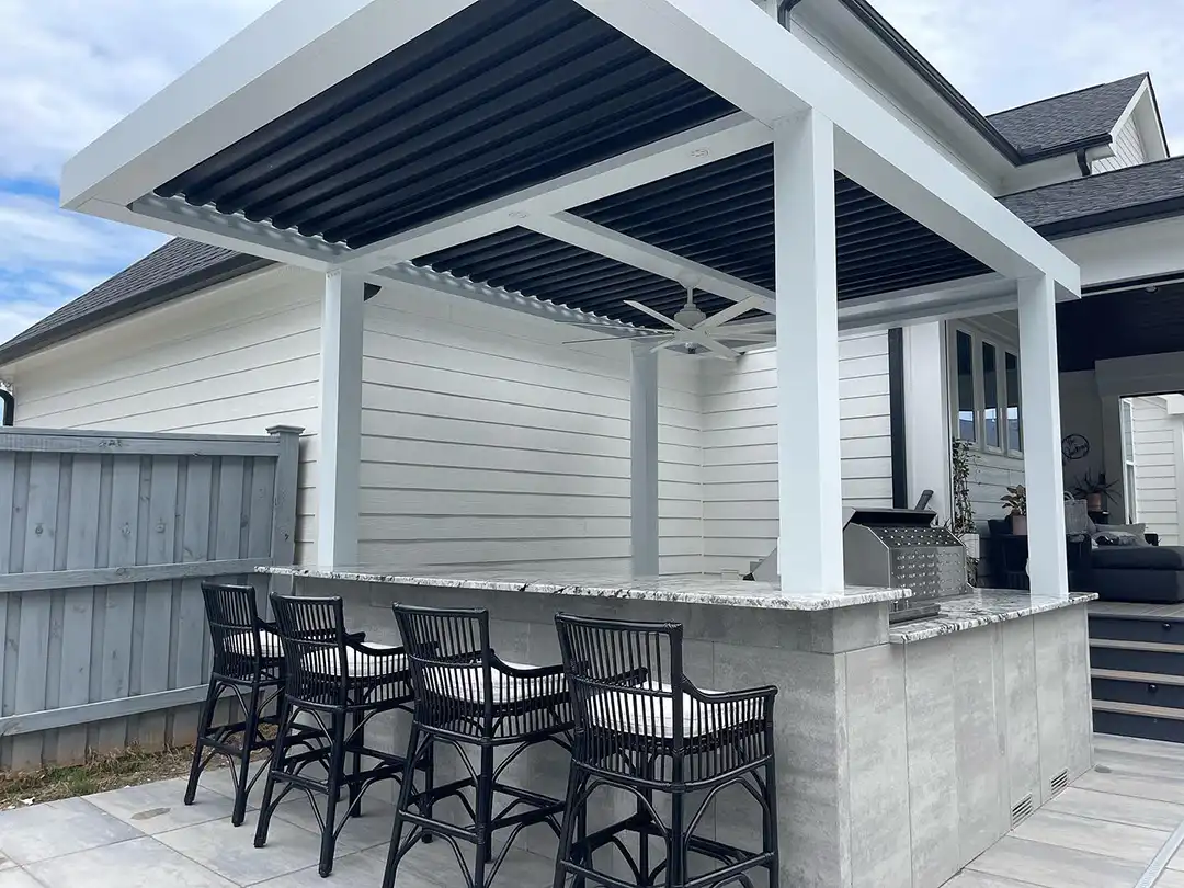 Photo Photo of a covered outdoor kitchen with bar seating.