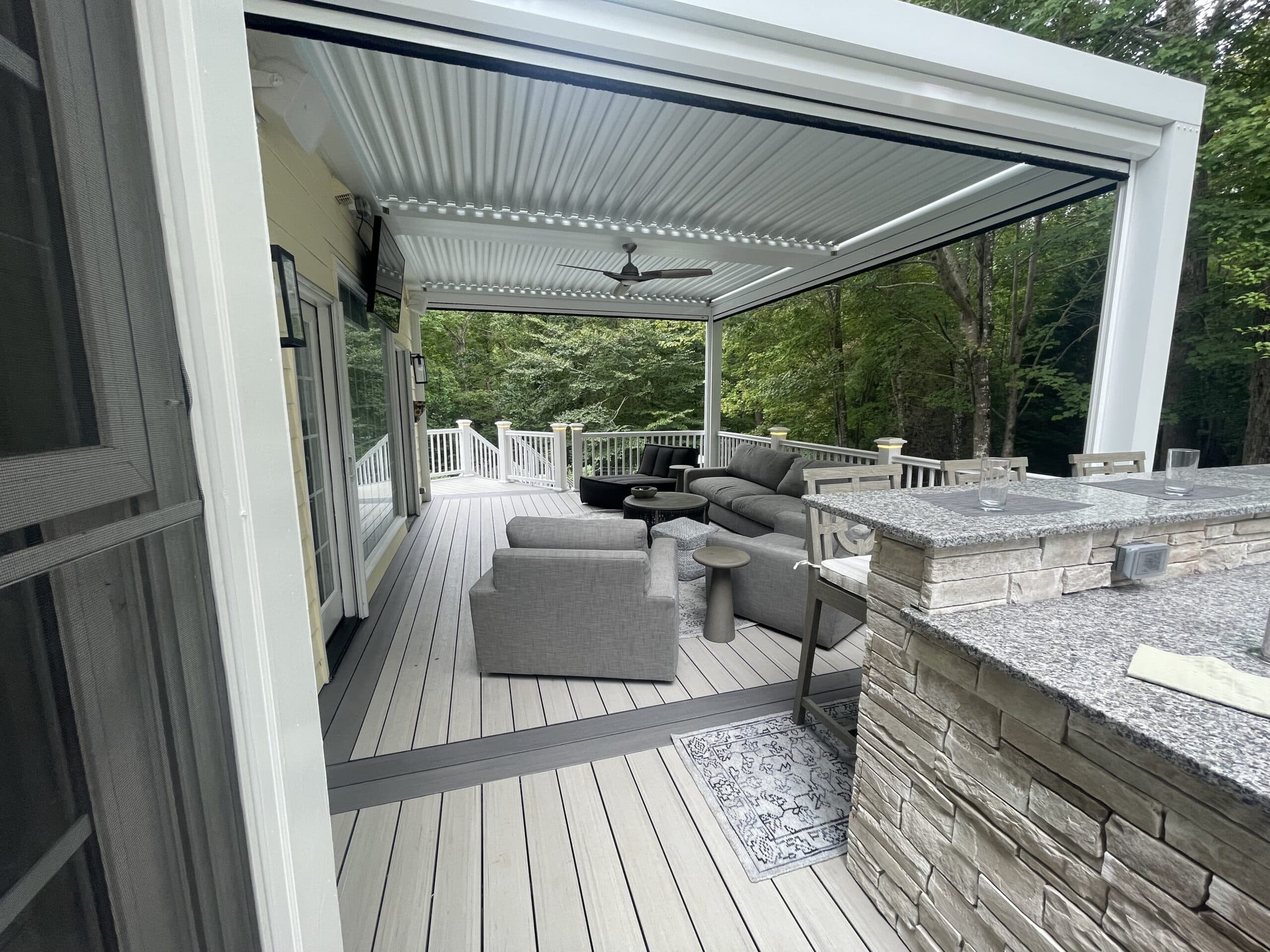 Photo of a new deck replacement with outdoor kitchen, TimberTech decking, outdoor furniture, and StruXure pergola - outdoor living project ideas