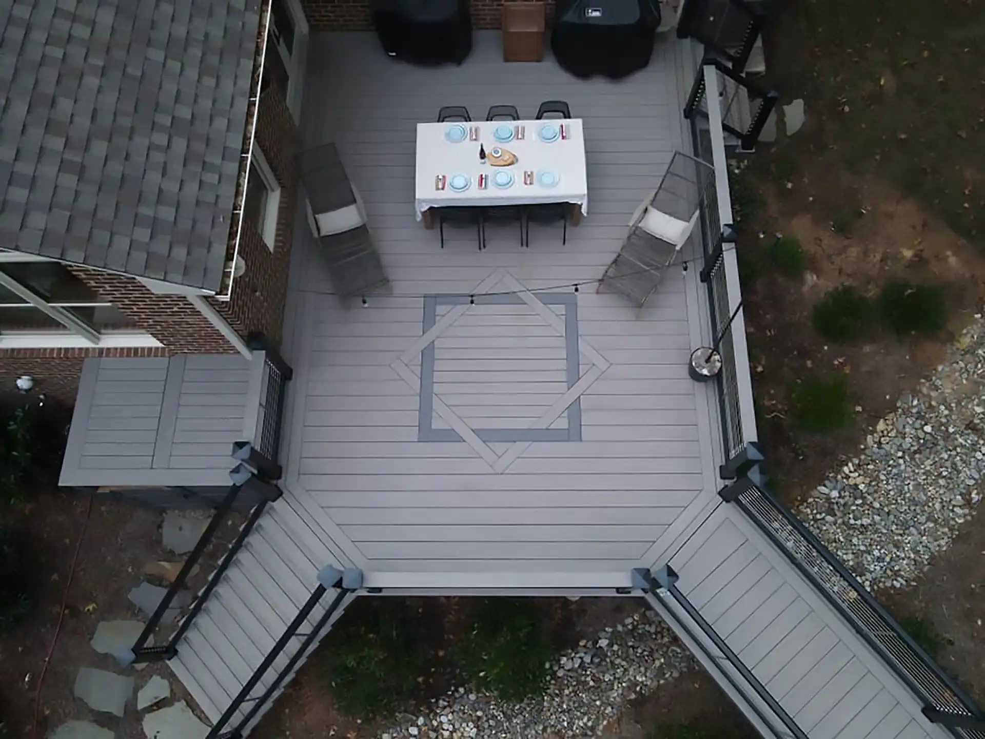 aerial view of a composite deck with a deck inlay, railing, and steps - Should I build a composite deck