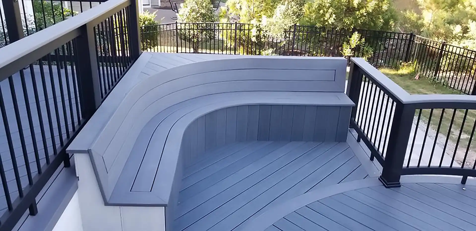 photo of a composite deck with built-in seating and deck railing - Composite decking maintenance services