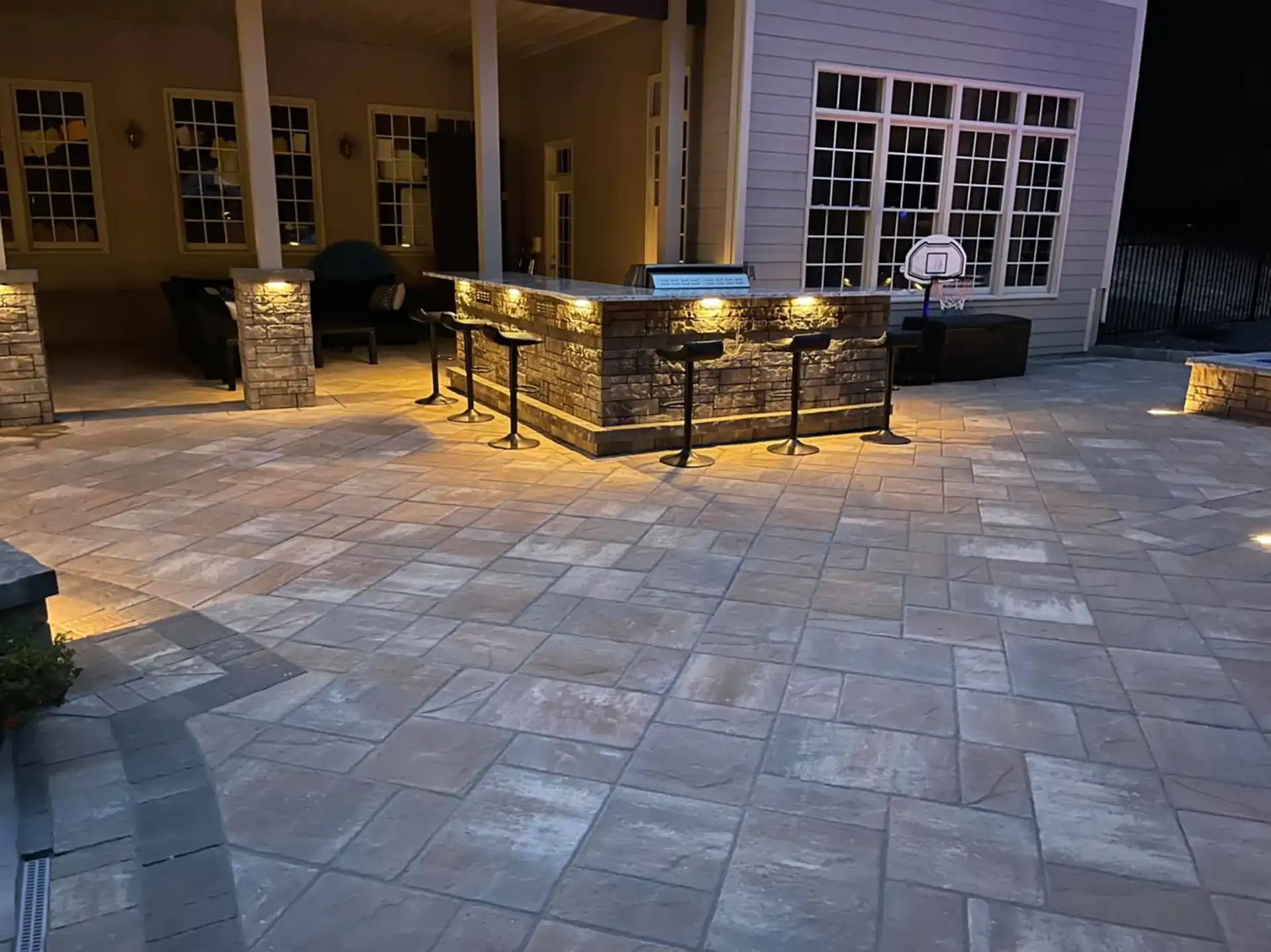 photo of a patio with an outdoor kitchen and bar - Should I build a Patio or a Deck