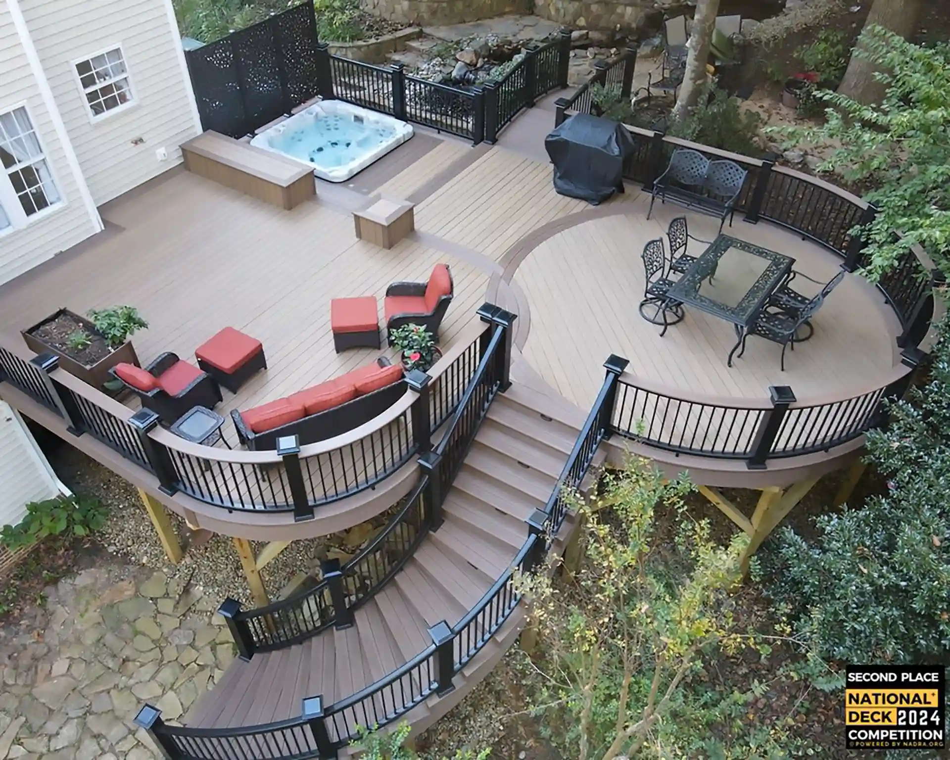 photo of elevated deck with curved section, winding staircase and hot tub