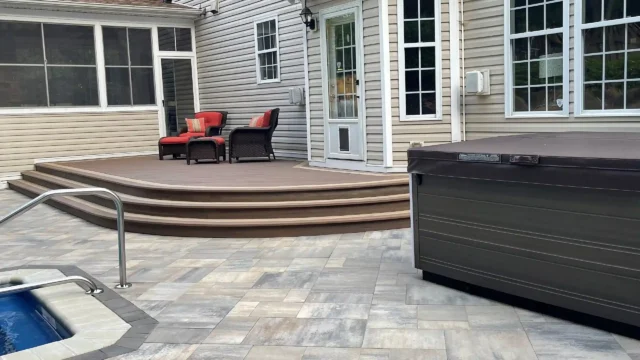 Photo of a custom curved deck with wide steps, patio, pool, and hot tub
