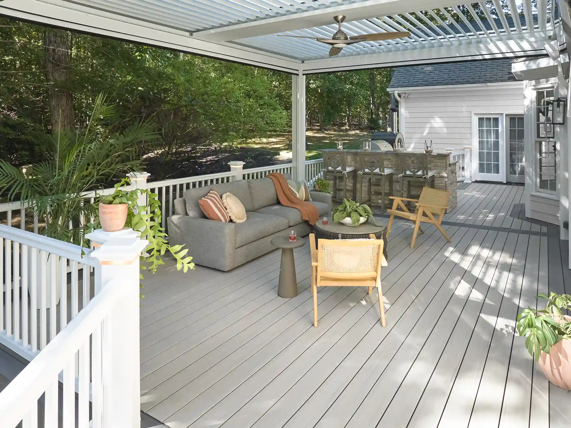 Photo of a covered deck with a louvered roof pergola with ceiling fan and outdoor furniture