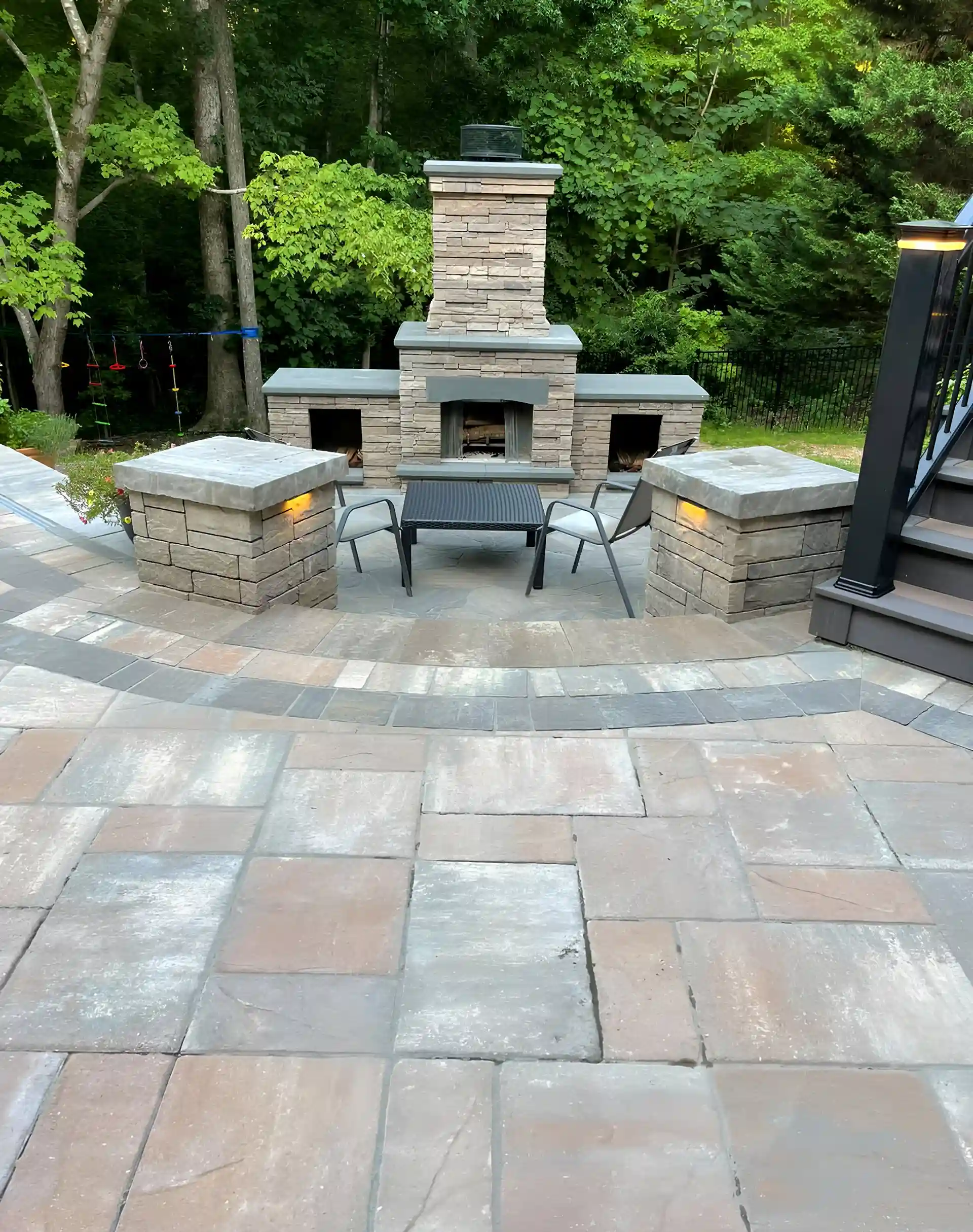 Photo of an elevated deck with patio and outdoor kitchen below.